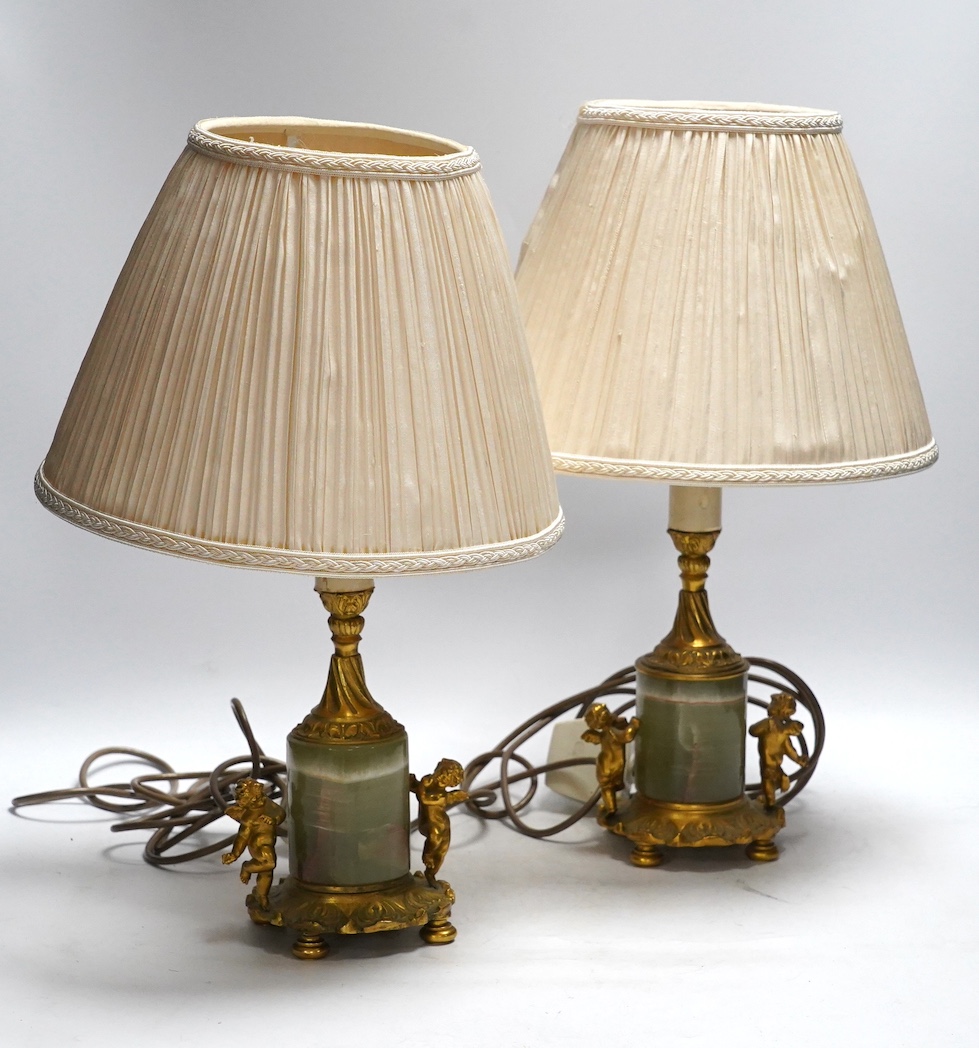 A pair of green onyx and gilt metal mounted cherub table lamps, 40cm high including the shades